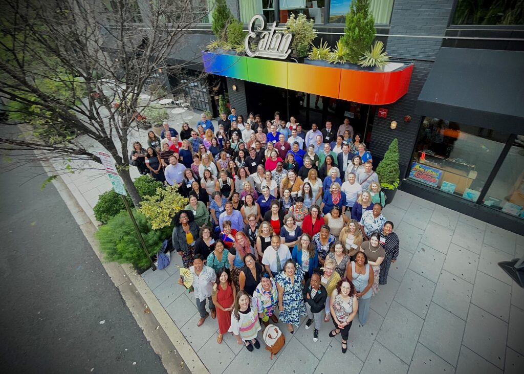 Group photo of Confab participants looking up at the camera from the sidewalk.